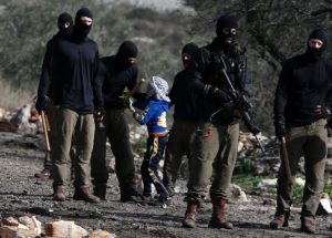 Masked members of the Israeli security forces briefly detain a Palestinian boy during clashes following a demonstration against the expropriation of Palestinian land by Israel in the village of Kfar Qaddum, near Nablus, in the occupied West Bank on December 23, 2016. / AFP / JAAFAR ASHTIYEH